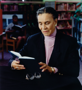 Rachel Noel reading a book in a library