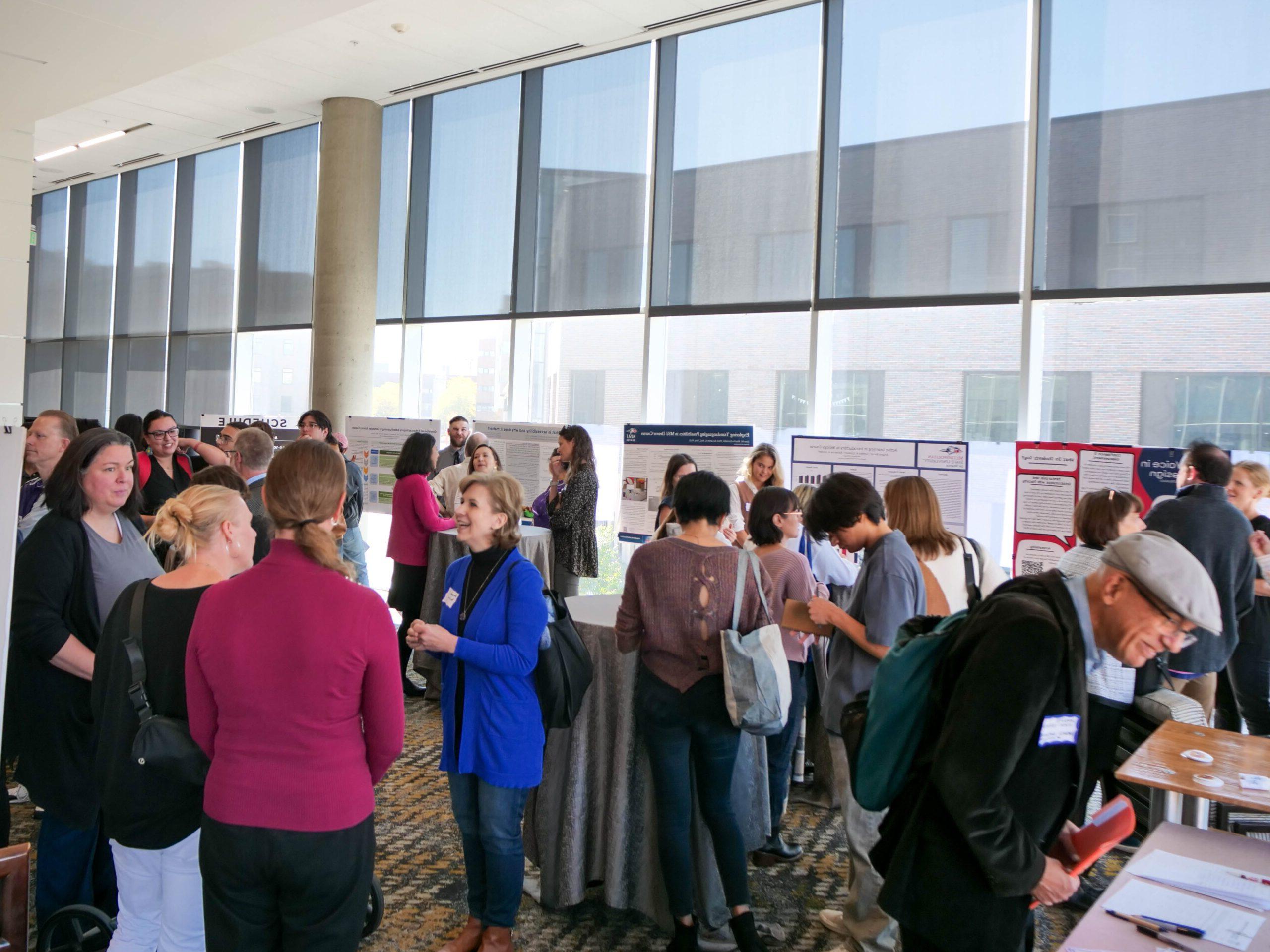 Faculty and staff discussing research projects at the SoTL poster session