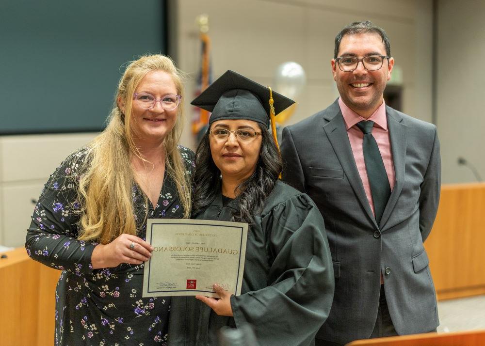 MSU Denver Staff stand with a GED Program Graduate