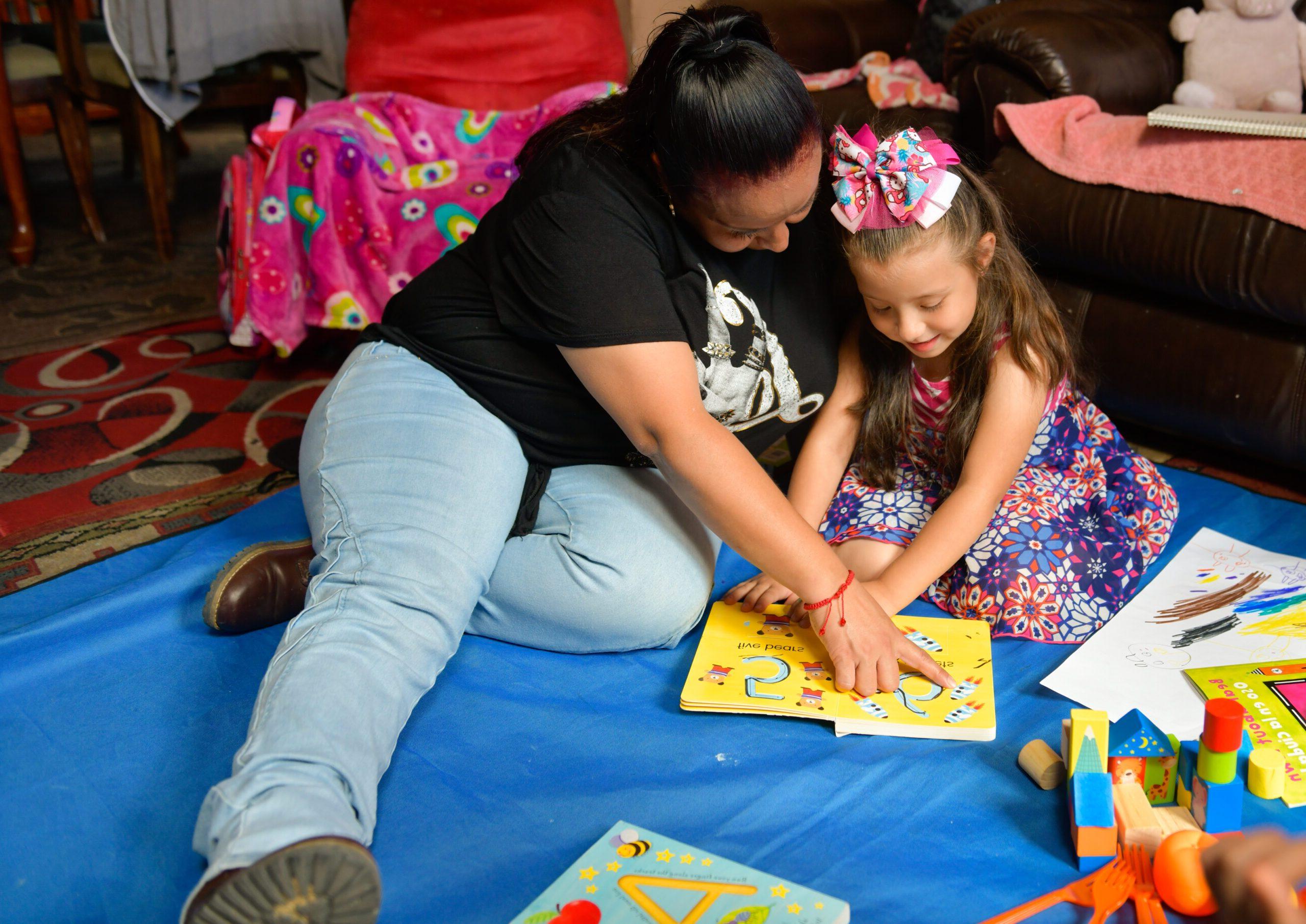 A parent and a child during a home visit read a book together